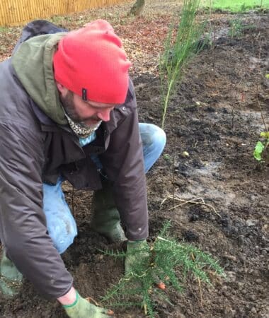 Ben Williams of Earthwatch Europe plants a tree in Littlemore Hospital's Tiny Forest