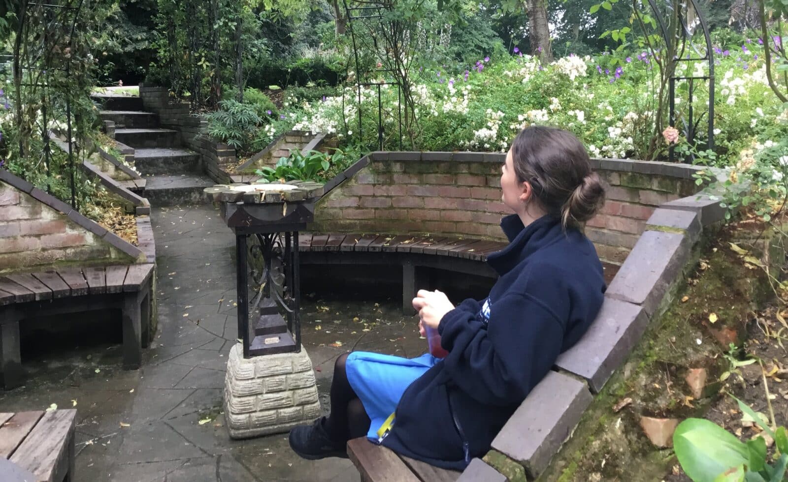 Staff member Clare sits in the Sunken Dell Garden at Broomfield Hospital