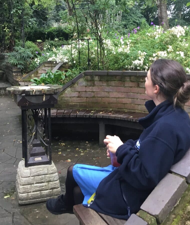 Staff member Clare sits in the Sunken Dell Garden at Broomfield Hospital