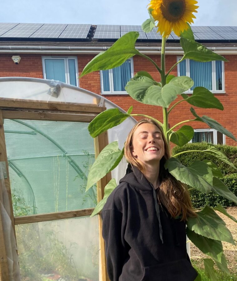 Bekki with sunflower at allotments at Avon and Wiltshire Mental Health Partnership NHS Trust. All rights reserved.